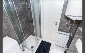 een douche met een glazen deur in een badkamer bij Apartment Punta with garage, balcony, garden and sea view in Opatija +7 foto's