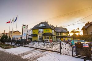 a yellow house with a fence in front of it at Royal House in Gdańsk