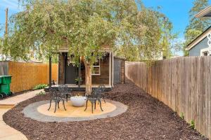 a patio with chairs and a tree and a fence at Unique Denver Tiny House Skiing, Shopping, Hiking in Englewood