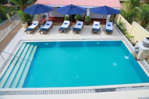 an overhead view of a swimming pool with lounge chairs and umbrellas at Sky and Sand Guesthouse in Beruwala