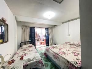 a room with two beds and a window at Aravilla Homestay Triple in Kota Belud