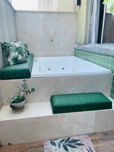 a bath tub with green cushions next to a window at Apartamento Mobiliado Condominio Conquista Torquato in Manaus
