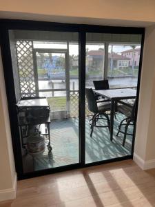 a sliding glass door with a table and a grill at WATER WATER WATER - newly renovated 3BR, 2 bath canal front home in Punta Gorda Isles in Punta Gorda +8 photos