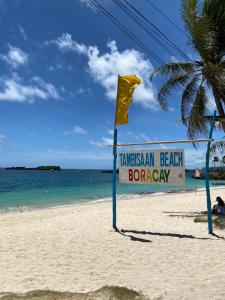 a sign on a beach with the ocean at Feliness Resort in Boracay