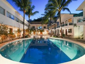 a large swimming pool in front of a building with palm trees at Feliness Resort in Boracay