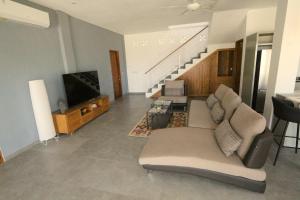 a living room with a couch and a flat screen tv at Saujana, Beachvilla with 3 bedrooms in Singaraja