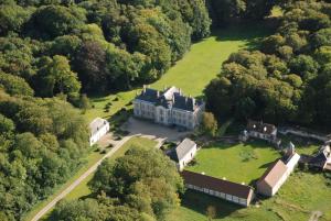 - une vue aérienne sur une grande maison dans la forêt dans l'établissement Château D'arry, à Arry