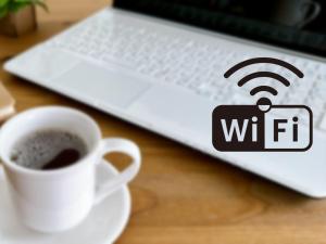 a cup of coffee and a laptop with a wifi sign on it at Meitetsu Inn Nagoya Nishiki in Nagoya