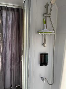 a bathroom with a shower curtain and a shelf and a window at Black Canyon Campground Modern Sleeping Pods Tiny Homes in Black Canyon City
