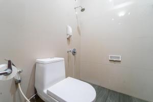 a bathroom with a toilet and a phone on the wall at Hotel Talenta 3 in Jetis +30 photos