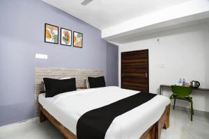 a bedroom with a large bed and a desk at Hotel O Kalyani Golden Key in Bālianta