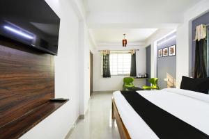 a bedroom with a bed and a tv on a wall at Hotel O Kalyani Golden Key in Bālianta