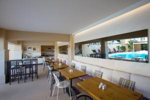restauracja ze stołami i krzesłami oraz basen w obiekcie La Stella Suites w mieście Platanes