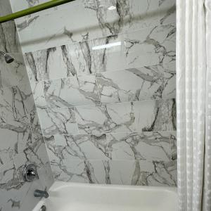 a bathroom with a marble shower curtain and a tub at Ramblin Rose Motel in Kingman +15 photos