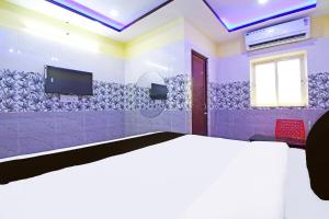 a bedroom with a bed and a tv on a wall at Hotel O Dreams Lodge in Bhubaneshwar +22 photos