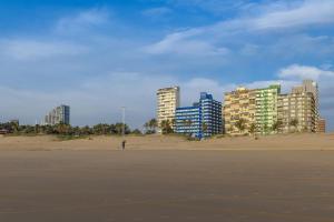 a person flying a kite on a beach with buildings at Shaka Shores 7E in Durban