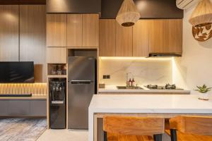 eine Küche mit Küchengeräten aus Edelstahl und Holzschränken in der Unterkunft Private Villa Ayra 8A by OriVista 10mins to Melasti Beach in Uluwatu