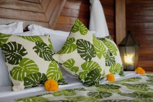 Una cama con almohadas verdes y blancas y una lámpara. en Wooden Stone Eco Villa, en Ubud