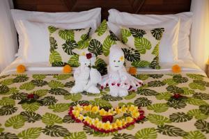 dos animales de peluche sentados encima de una cama en Wooden Stone Eco Villa, en Ubud 73 fotos más