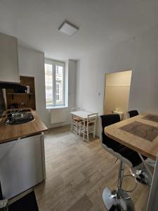 a room with a kitchen and a table with chairs at La famille 1 in Angoulême