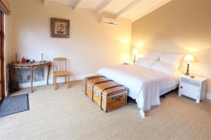 a bedroom with a white bed with a suitcase at The Little Nest in Sedgefield