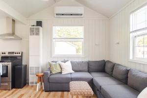 a living room with a gray couch in a kitchen at Lakeside Retreat - Cozy Cottage with Firepit in Hartland