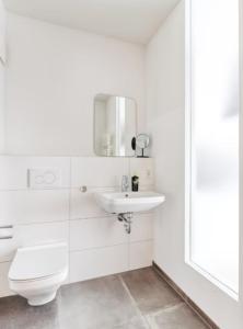 a white bathroom with a toilet and a sink at My Suite II - Augsburg City - Netflix in Augsburg