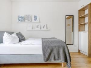 a white bedroom with a bed and a mirror at My Suite II - Augsburg City - Netflix in Augsburg