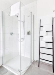 a shower with a glass door in a bathroom at My Suite II - Augsburg City - Netflix in Augsburg