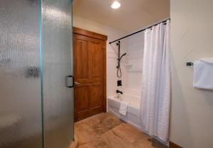a bathroom with a tub and a shower with a glass door at Premium Unit 2801 - Zephyr Mountain Lodge condo in Winter Park