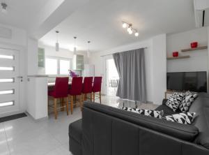 ein Wohnzimmer mit einem Sofa und roten Stühlen in der Unterkunft Modern Villa Near the Sea in Blato