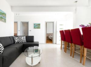 ein Wohnzimmer mit einem schwarzen Sofa und roten Stühlen in der Unterkunft Modern Villa Near the Sea in Blato + 40 Fotos