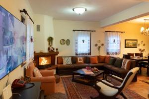 a living room with a couch and a fireplace at Ersis Retreat in Kalyvia