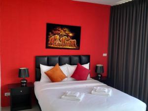 a red bedroom with a large bed with red walls at Dorothys in Pattaya South