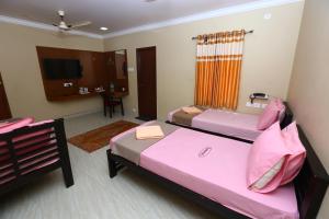 a hotel room with two beds and a bathroom at Ramana's Home Stay-Near Railway Station and Bus Stand in Thanjāvūr