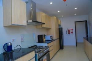a kitchen with wooden cabinets and a stove top oven at 300 Rentals in Dar es Salaam
