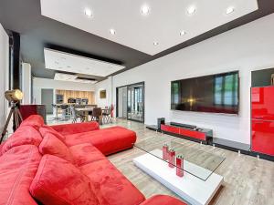 a living room with a red couch and a flat screen tv at LOFT Terrasse avec SPA proche centre historique in Montluçon