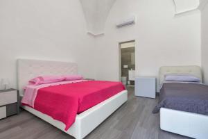 a bedroom with two beds with pink and purple sheets at Casa Silvana in Copertino
