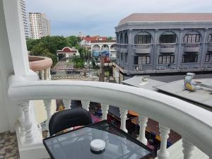 a chair on a balcony with a view of a city at Dorothys in Pattaya South