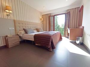 een slaapkamer met een bed en een groot raam bij Hotel Rambla Emérita, centro ciudad in Merida