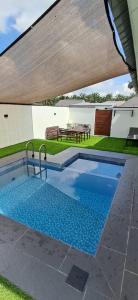 a swimming pool in a yard with a patio at Tiny Tijani Homestay in Kulai