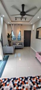 a living room with a couch and a ceiling fan at Tiny Tijani Homestay in Kulai