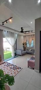 a living room with a couch and a living room with a room at Tiny Tijani Homestay in Kulai