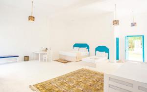 a living room with white walls and blue chairs at Epic Wild Wilpattu exclusive private villa in Wilpattu +33 photos