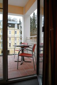 a balcony with a table and a chair at Apartmany Cesky Dvur in Mariánské Lázně