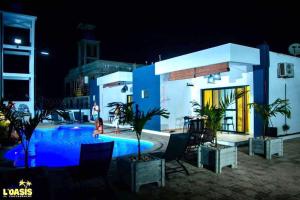 a house with a swimming pool at night at Résidence LOASIS in Mahajanga