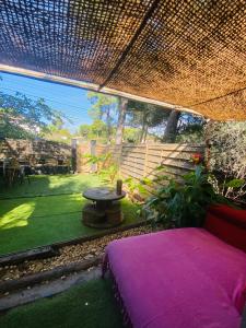 a bedroom with a purple bed and a table in a yard at Logement indépendant avec parking dans un quartier de standing proche de la plage in Les Lecques