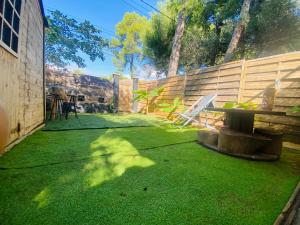 a backyard with green grass and a wooden fence at Logement indépendant avec parking dans un quartier de standing proche de la plage in Les Lecques