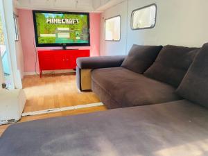 a living room with a couch and a tv at Logement indépendant avec parking dans un quartier de standing proche de la plage in Les Lecques