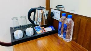 a shelf with bottles of water and a kettle at Hotel Pravasa Stay, Dewas Naka in Indore